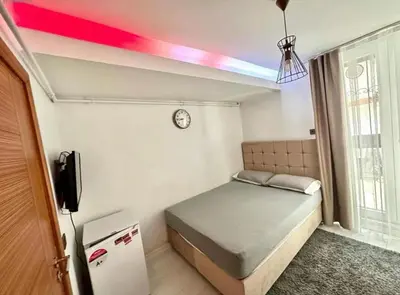 a small bedroom with a bed and a rainbow painted on the ceiling at Innova Suit Hotel in Istanbul