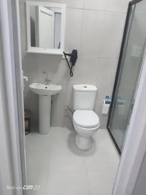 a white bathroom with a toilet and a sink at Tekirdağ Begonya Hotel in Kapaklı