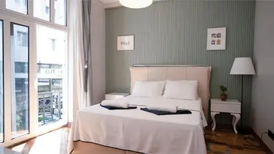 a bedroom with a bed with white sheets and a window at Taksim Green Flat Apartment 2 in Istanbul