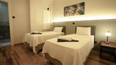 a hotel room with two beds with white sheets at Taksim Green Flat Apartment 2 in Istanbul