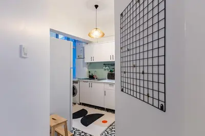 a kitchen with white cabinets and a tile wall at 2BR Historical apartment 5 min to Taksim Sq in Istanbul