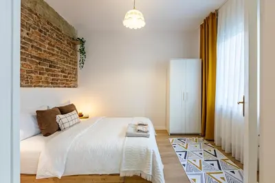a bedroom with a white bed and a brick wall at 2BR Historical apartment 5 min to Taksim Sq in Istanbul