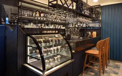 a bar with a display case with glasses at Hotel De Bonte in Istanbul
