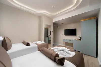 a hotel room with two beds and a flat screen tv at Hotel De Bonte in Istanbul