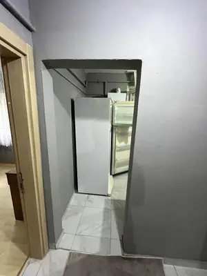 an empty kitchen with a refrigerator in a room at Taksim metro central Suites hotel in Istanbul