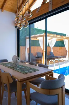 a dining room with a wooden table and chairs at Villa Wonka Sapanca Sıcak Havuz in Sapanca