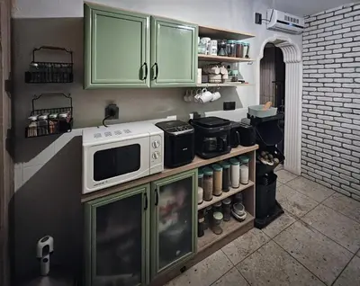 a kitchen with green cabinets and a microwave at Villa Nest Uludağ in Hüseyinalan