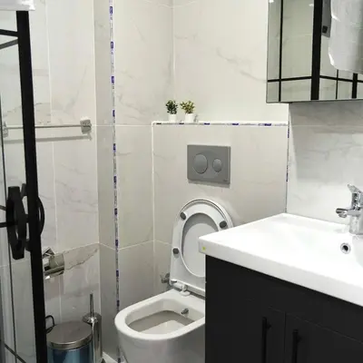 a white bathroom with a toilet and a sink at Accommodation Near the Bull Statue in Kadikoy in Istanbul
