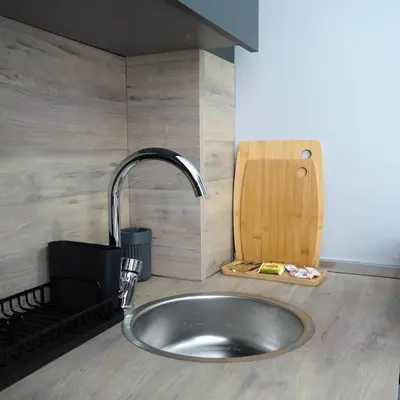 a kitchen counter with a sink and a wooden cutting board at Accommodation Near the Bull Statue in Kadikoy in Istanbul