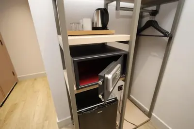 a room with a shelf and a microwave oven at The Diamond City Hotel Yenikapı in Istanbul