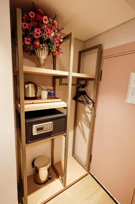 a kitchen with a shelf with a microwave and flowers at The Diamond City Hotel Yenikapı in Istanbul