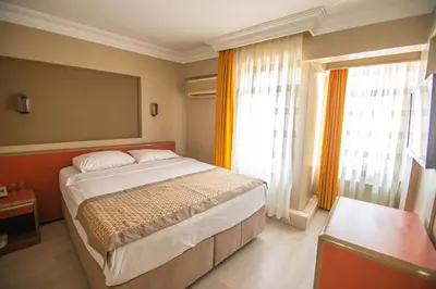 a bedroom with a large bed and two windows at Sahinler Hotel in Istanbul
