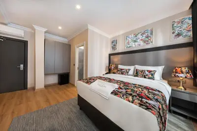 a bedroom with a large bed and two windows at Bond Hotel in Istanbul