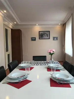 a table with plates and napkins and a vase of flowers at Apartment on Pier Loti street with a nice view in Istanbul