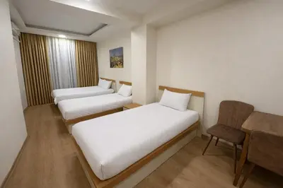 a hotel room with two beds and a chair at VALENCE SUITES Taksim in Istanbul