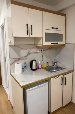 a small kitchen with white cabinets and a sink at VALENCE SUITES Taksim in Istanbul