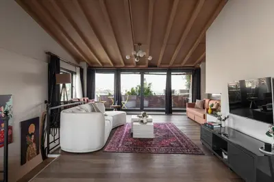 a living room with a white couch and a tv at Iconic Sea View Duplex w Terrace in Balat in Istanbul