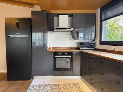 a kitchen with stainless steel appliances and a window at Iconic Sea View Duplex w Terrace in Balat in Istanbul