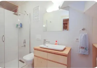 a white bathroom with a sink and a shower at Two seperate apartments for friends and families in Istanbul