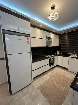 a kitchen with white cabinets and a refrigerator at Villa life in Gümüşyaka