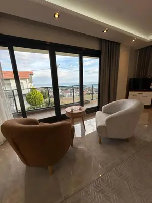 a living room with two chairs and a large window at Villa life in Gümüşyaka