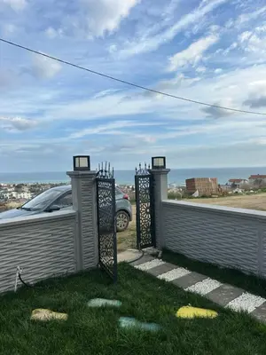 a fence with a car parked in the grass at Villa life in Gümüşyaka