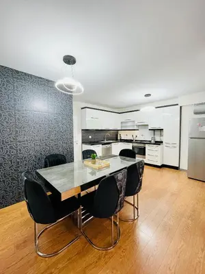 a kitchen with a dining room table and black chairs at ekinci cihangir in Istanbul
