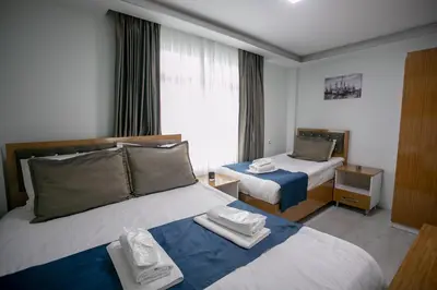 a hotel room with two beds and a window at Güven House İstanbul in Istanbul