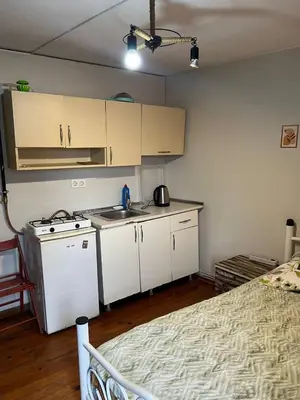 a kitchen with white cabinets and a bed in a room at suite near Taksim square in Istanbul