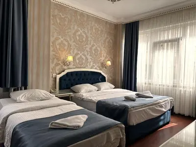 a hotel room with two beds and a window at Alyon Hotell in Istanbul