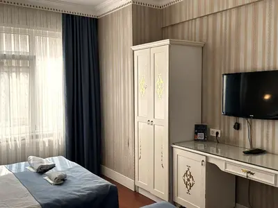 a bedroom with a bed and a cabinet and a television at Alyon Hotell in Istanbul