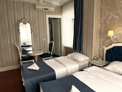 a hotel room with two beds and a mirror at Alyon Hotell in Istanbul