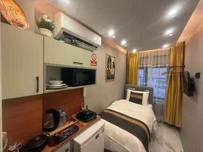 a small room with a bed and a television at Cozy Studio Near Taksim Metro Station in Istanbul