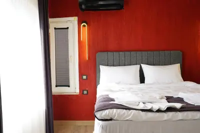a bed in a room with a red wall at the apart galata in Istanbul