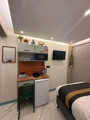 a bedroom with a bed and a desk in a room at Modern Compact Studio Near Metro Station in Istanbul