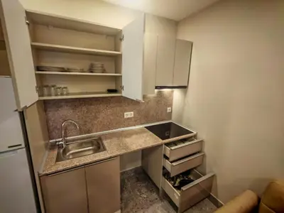 a small kitchen with white cabinets and a sink at Suitev in Arnavutköy
