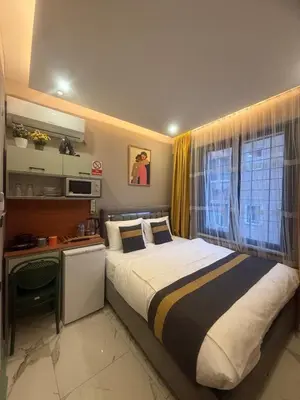 a bedroom with a bed with a desk and a window at Warm cozy studio 8 min by metro station in Istanbul