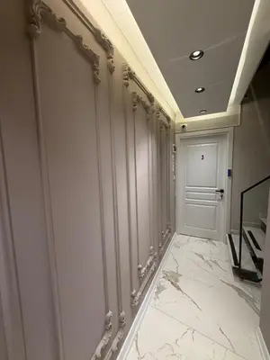 a hallway with white marble floors and a white door at cozy studio apt near to taksim square in Istanbul
