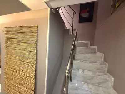 a stairway with white marble stairs and a metal door at Cozy duplex with a private terrace near the metro in Istanbul