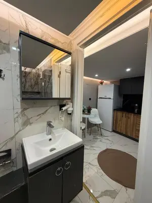 a bathroom with a sink and a mirror and a kitchen at Cozy duplex with a private terrace near the metro in Istanbul