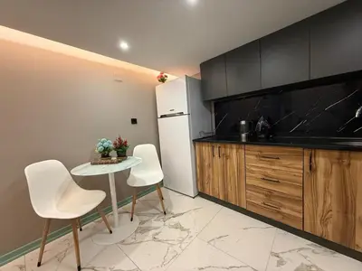 a kitchen with a white refrigerator and a table and chairs at Cozy duplex with a private terrace near the metro in Istanbul