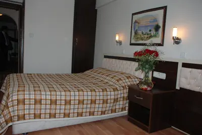 a bedroom with a bed and a vase of flowers on a table at Hotel Grand Mark in Istanbul