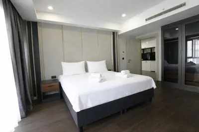 a bedroom with a large white bed with white pillows at Hilloria Residence Hotel in Serdivan