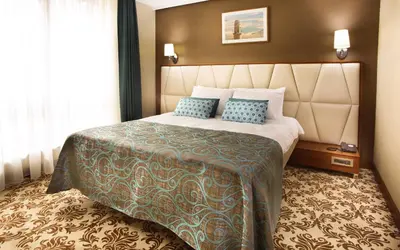 a hotel room with a large bed with blue pillows at Mard-inn Hotel in Istanbul