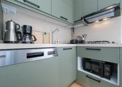 a kitchen with white cabinets and a stove top oven at acme studio in Istanbul
