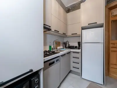 a kitchen with white cabinets and a refrigerator at acme studio in Istanbul