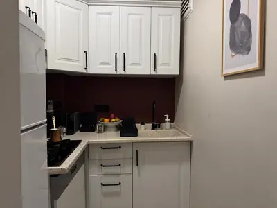 a kitchen with white cabinets and a white refrigerator at Stylish Apartment 3 Min to Metro in Istanbul
