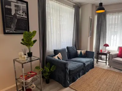 a living room with a blue couch and a chair at Stylish Apartment 3 Min to Metro in Istanbul