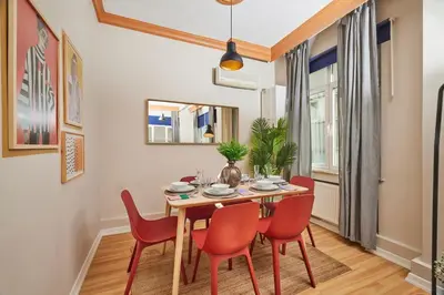 a dining room with a wooden table and red chairs at Prime Nişantaşı 2BR Flat 3-Min Walk to Metro in Istanbul