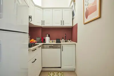 a kitchen with white cabinets and a refrigerator at Comfortable 2BR Flat in Nişantaşı Near Metro in Istanbul
